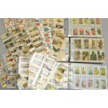 THREE CIGARETTE CARD ALBUMS, containing approximately one thousand six hundred cigarette cards, a