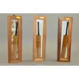 MINIATURE SIGNED CRICKET BATS, housed in individual wood and glass cases, teams are Australia and