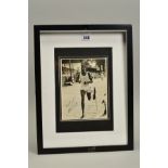 FRAMED AND GLAZED PHOTOGRAPH, of an unknown athlete crossing the finishing line in a race, the