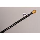 A LATE VICTORIAN 18 CARAT GOLD MOUNTED EBONISED WALKING CANE, the foliate embossed mount
