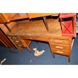 A MID 20TH CENTURY OAK DESK with seven various drawers