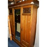 AN ART NOUVEAU OAK TRIPLE DOOR COMPACTUM WARDROBE with a central mirrored door, width 165cm x