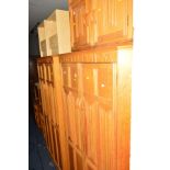 A LIGHT OAK LINENFOLD SEVEN PIECE BEDROOM SUITE, comprising a two double door wardrobe, dressing