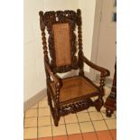 A VICTORIAN AND LATER CAROLEAN STYLE CARVED WALNUT AND WALNUT STAINED ELBOW CHAIR, caned back and