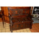 AN EARLY 20TH CENTURY CARVED OAK MONK'S BENCH, recumbant lion armrests, hinged seat, width 104cm x