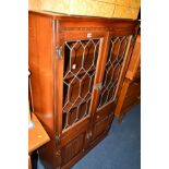 AN OLD CHARM OAK LEAD GLAZED TWO DOOR BOOKCASE, above double cupboard linenfold doors, width 92cm