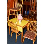 A YELLOW FORMICA TOPPED DROP LEAF KITCHEN TABLE, three spindle hoop back chairs and two small