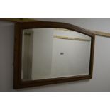 AN EARLY 20TH CENTURY OAK FRAMED BEVELLED EDGE WALL MIRROR with an arched top, 93cm x 62cm