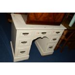 A PAINTED EDWARDIAN DESK with seven drawers