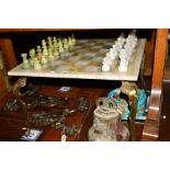 AN ONYX TOPPED CHESS TABLE, on a brass frame, with a set of onyx chess pieces, together with an