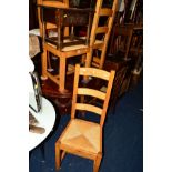 A SET OF FOUR GOLDEN OAK RUSH SEATED LADDER BACK CHAIRS