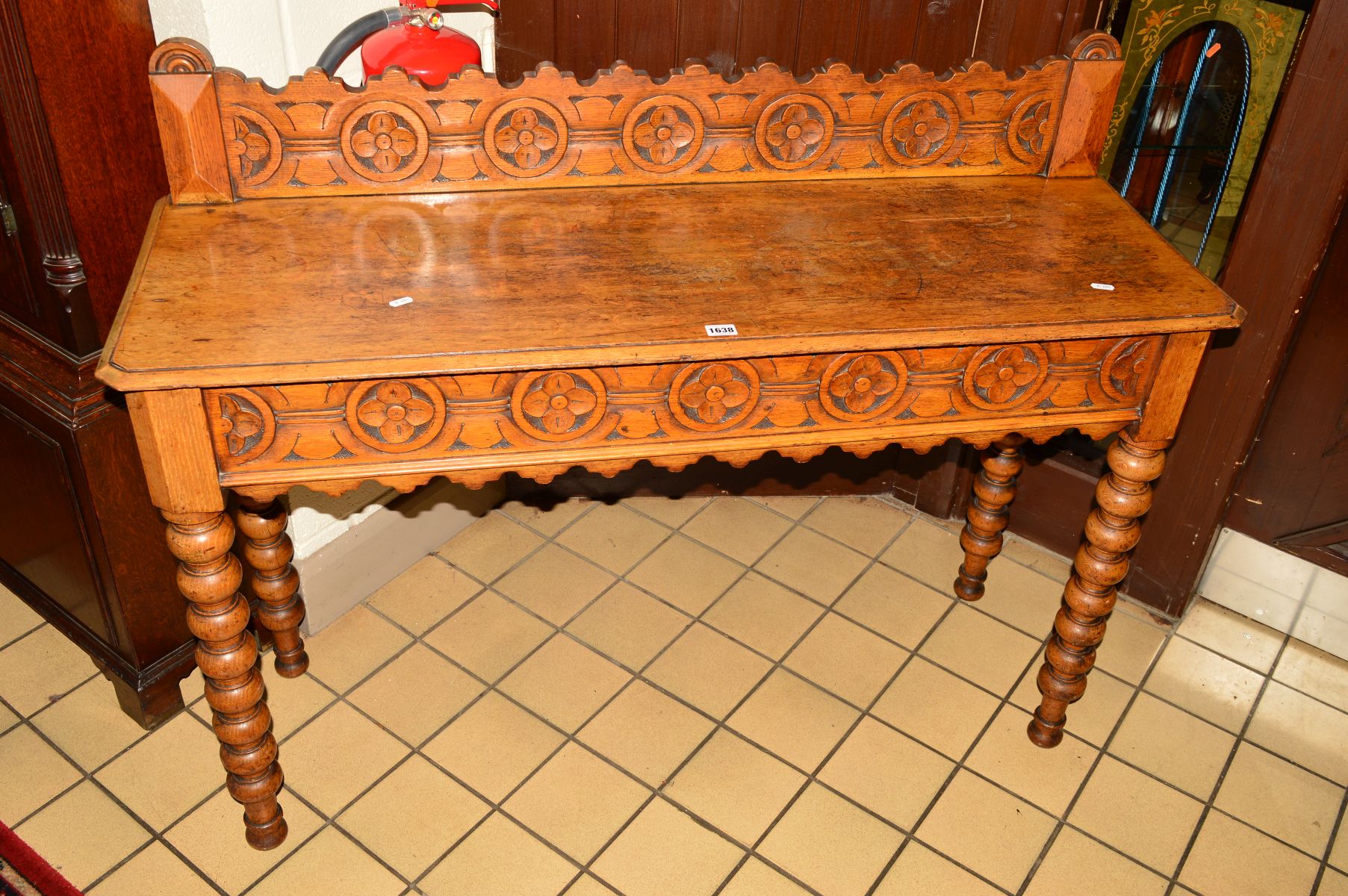 A VICTORIAN OAK SIDE TABLE, the foliate carved back above rectangular top, on bobbin turned legs,