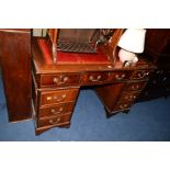 A MAHOGANY PEDESTAL DESK with a tooled red leather top and nine various drawers, width 122cm x depth