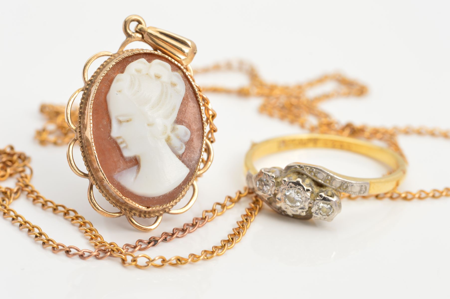 A THREE STONE DIAMOND RING AND A 9CT CAMEO PENDANT NECKLACE, ring designed as three single cut