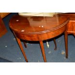 AN EDWARDIAN MAHOGANY AND WALNUT BANDED DEMI LUNE FOLD OVER TEA TABLE on square tapering legs and
