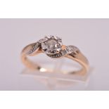 A 9CT GOLD DIAMOND RING, designed as a central round brilliant cut diamond in a four claw illusion