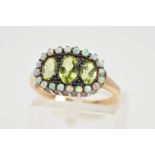 A PERIDOT AND OPAL RING, designed with three faceted oval shape peridots within an opal surround