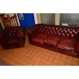 A REPRODUCTION BUTTON BACK CHESTERFIELD AND ARMCHAIR IN OX BLOOD RED LEATHER, length 190cm x depth