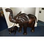 A LEATHER COVERED MODEL OF AN ELEPHANT, plastic tusks, length 151cm approximately x height 137cm