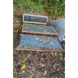 A TEAK SLATTED GARDEN BENCH WITH CAST IRON ENDS, together with two similar tables supported on a