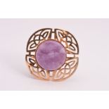 AM 9CT GOLD AMETHYST BROOCH, designed as a tiered circular amethyst centre with Celtic design
