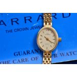 A 9CT LADIES GARRARD WRISTWATCH, silvered dial with batons, oval case, brick link bracelet, engraved