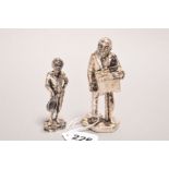 TWO NICKEL FIGURES OF A BOY WITH CAP AND A STREET PERFORMERS, heights 8cm and 10cm (2)