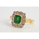 AN 18CT EMERALD AND DIAMOND CLUSTER RING, a central rectangular emerald measuring approximately 7.