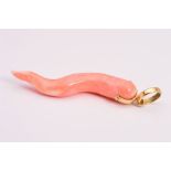 A CORAL PENDANT, designed as a piece of polished coral to the circular suspension loop, length 65mm,