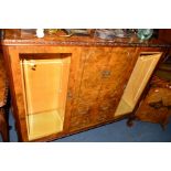 A REPRODUCTION BURR WALNUT BOOKCASE, with two glazed doors flanking central double cupboard doors