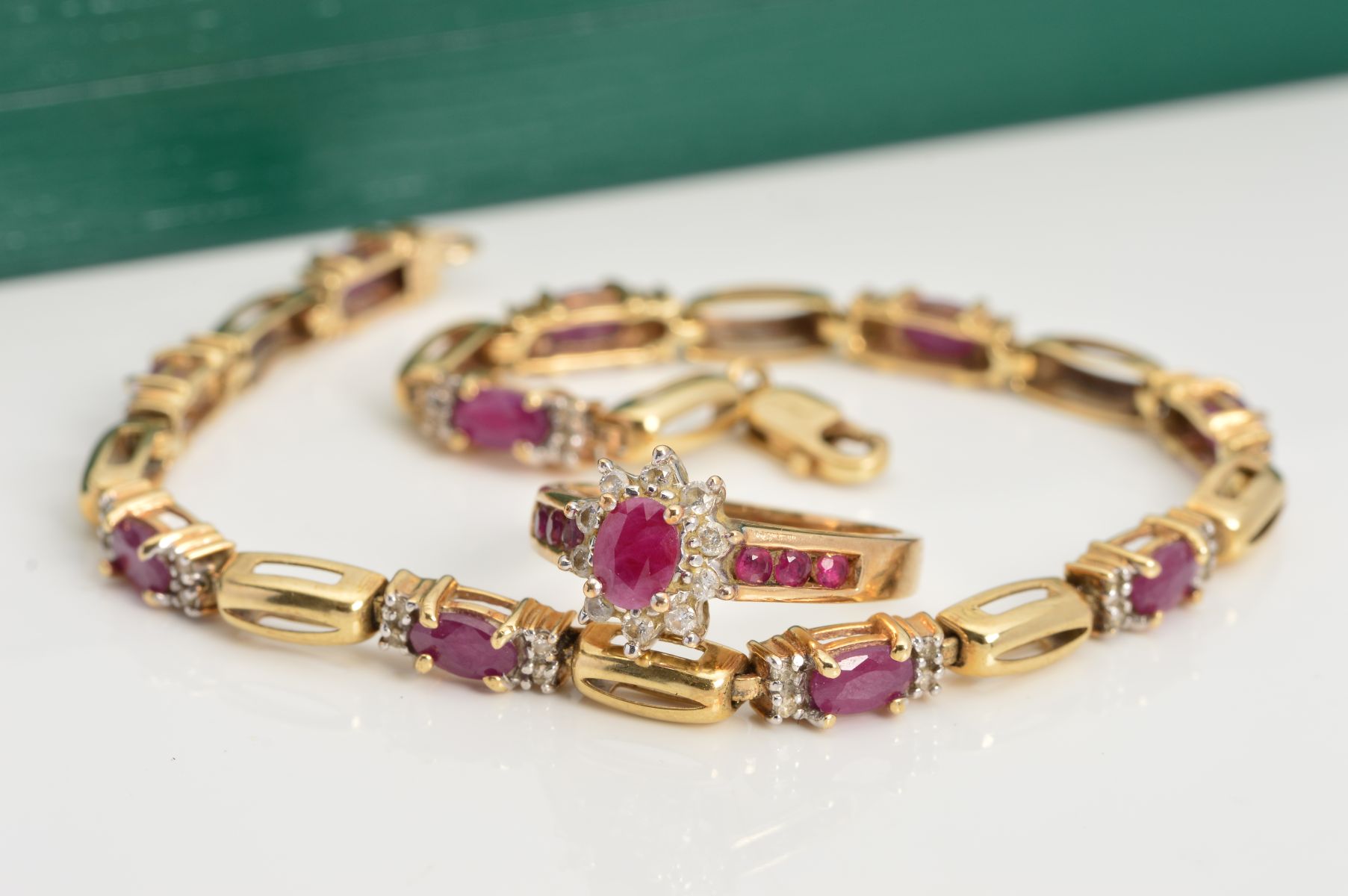 A 9CT GOLD DIAMOND AND RUBY RING AND BRACELET, the tiered cluster ring with central ruby to the