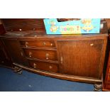 AN EARLY 20TH CENTURY OAK BOW FRONT SIDEBOARD, with three central drawers and drop brass handles,