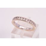 AN 18CT WHITE GOLD DIAMOND HALF ETERNITY RING, channel set with seventeen round brilliant cut