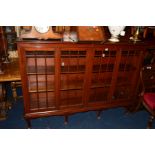 AN EDWARDIAN REPRODUCTION STYLE GLAZED FOUR DOOR BOOKCASE with adjustable shelves on carved cabriole