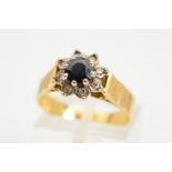 AN 18CT GOLD SAPPHIRE AND DIAMOND CLUSTER RING, the central circular sapphire within a single cut