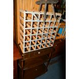 A DARK ERCOL ELM THREE TIER TEA TROLLEY, a 19th Century oak milking stool and a wine rack (3)