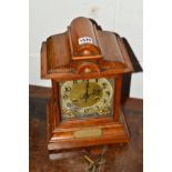 AN EARLY 20TH CENTURY OAK MANTEL CLOCK, brass spandrels, Arabic numerals and brass presentation