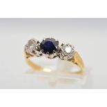 AN 18CT DIAMOND AND SAPPHIRE RING, designed in a row with a central circular sapphire within an