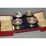 A CASED SET OF FOUR GEORGE V SILVER PEDESTAL NUT DISHES, wavy rims above pierced bowls, on slender