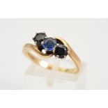 A 9CT GOLD THREE STONE SAPPHIRE RING, designed as a diagonal line of three circular sapphires in