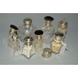 EIGHT LATE 19TH TO EARLY 20TH CENTURY GLASS LIDDED SCENT AND SALT BOTTLES, three with silver