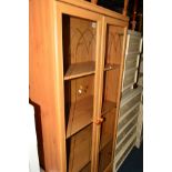 A PINE GLAZED DOUBLE DOOR BOOKCASE above a single drawer
