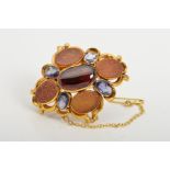 A LATE VICTORIAN GOLD GEM BROOCH, set with a central oval garnet cabochon within a surround of