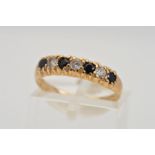 A 9CT GOLD SEVEN STONE RING, designed as a row of four circular sapphires interspaced by circular