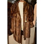 A THIGH LENGTH MUSQUASH COAT, having shawl collar and turn back cuffs, a faux fur shrug, a