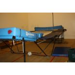 A TRAMPOLINE WITH FOLDING FRAME, with two Nissen end mats on stands and two other deeper mats