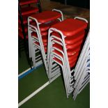 FOURTEEN STACKING CLASSROOM STOOLS, with red plastic shaped seats on a grey tubular metal base