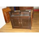 AN EDWARDIAN STAINED PINE TWO DOOR BOOKCASE, with brass handles, 106x30x100cm high (s.d)