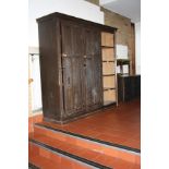 AN EDWARDIAN STAINED PINE HOUSE KEEPERS CUPBOARD, with three panelled doors with round brass handles