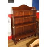 A MODERN REPRODUCTION CASCADE BOOKCASE, with three fixed shelves over three drawers with brass